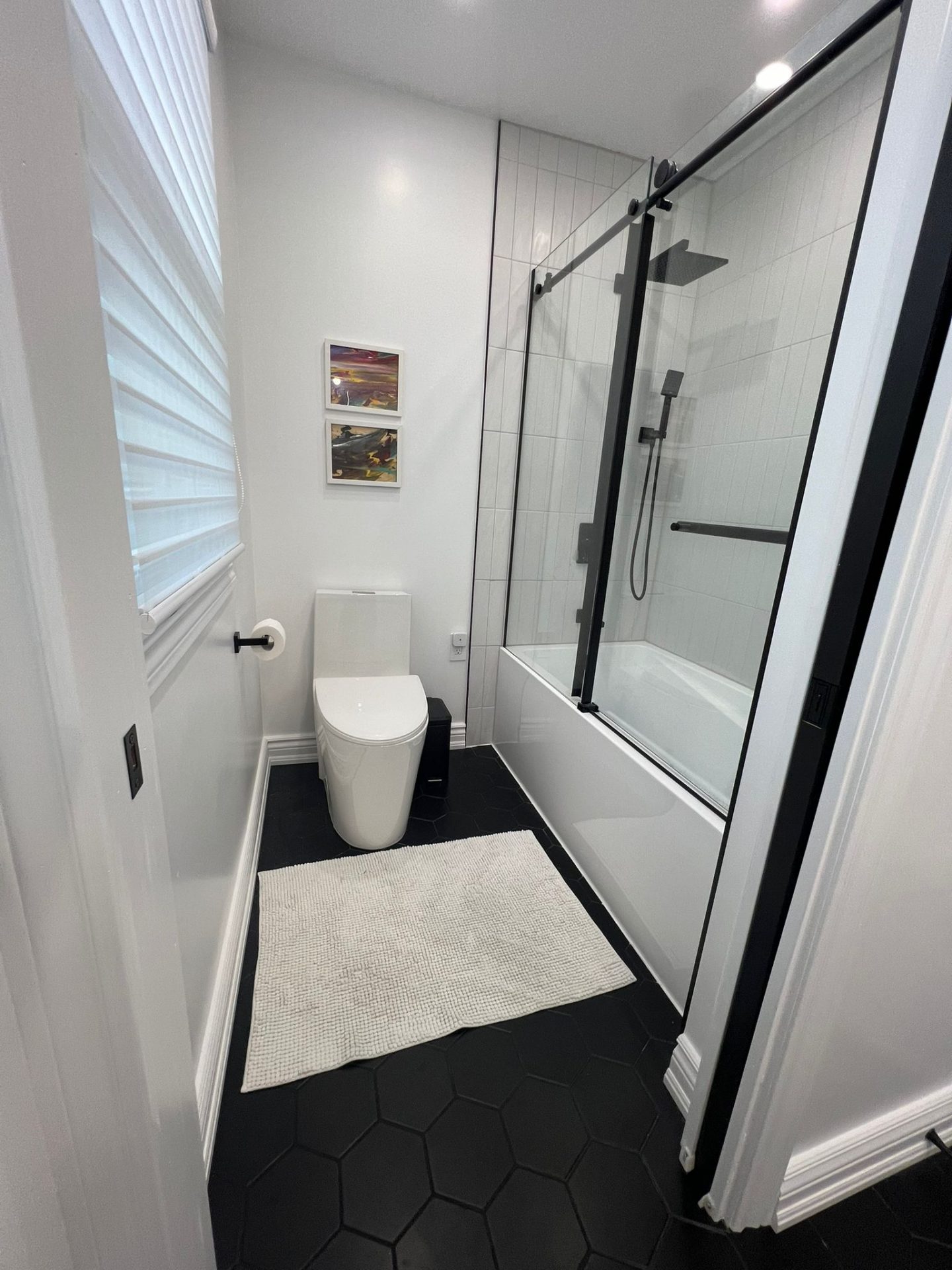 Modern bathroom with glass shower and black tile floor