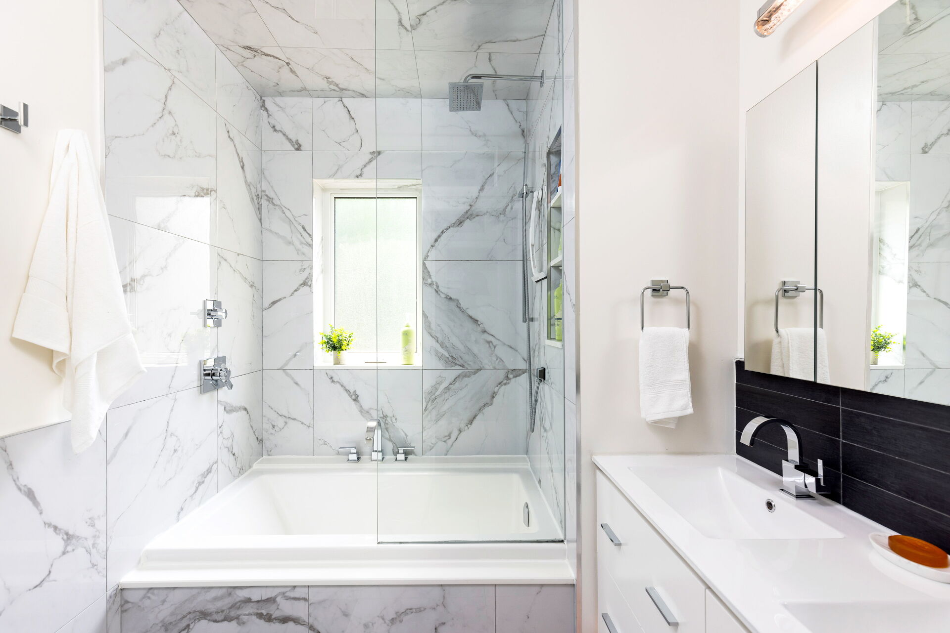 Modern marble bathroom with tub and glass shower