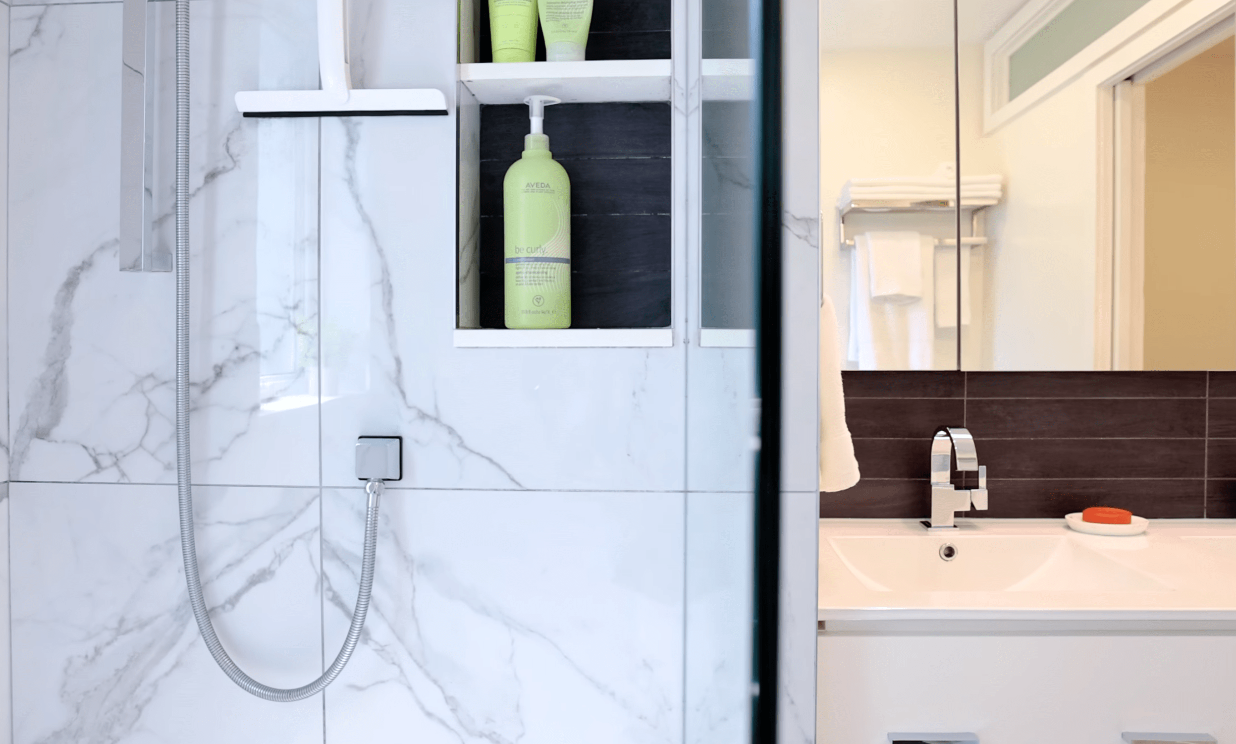 Modern marble shower with built-in shelf and sink