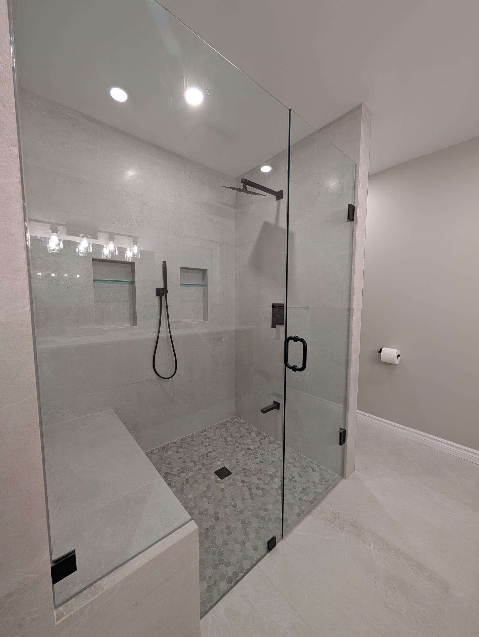 Modern glass-enclosed shower with black fixtures