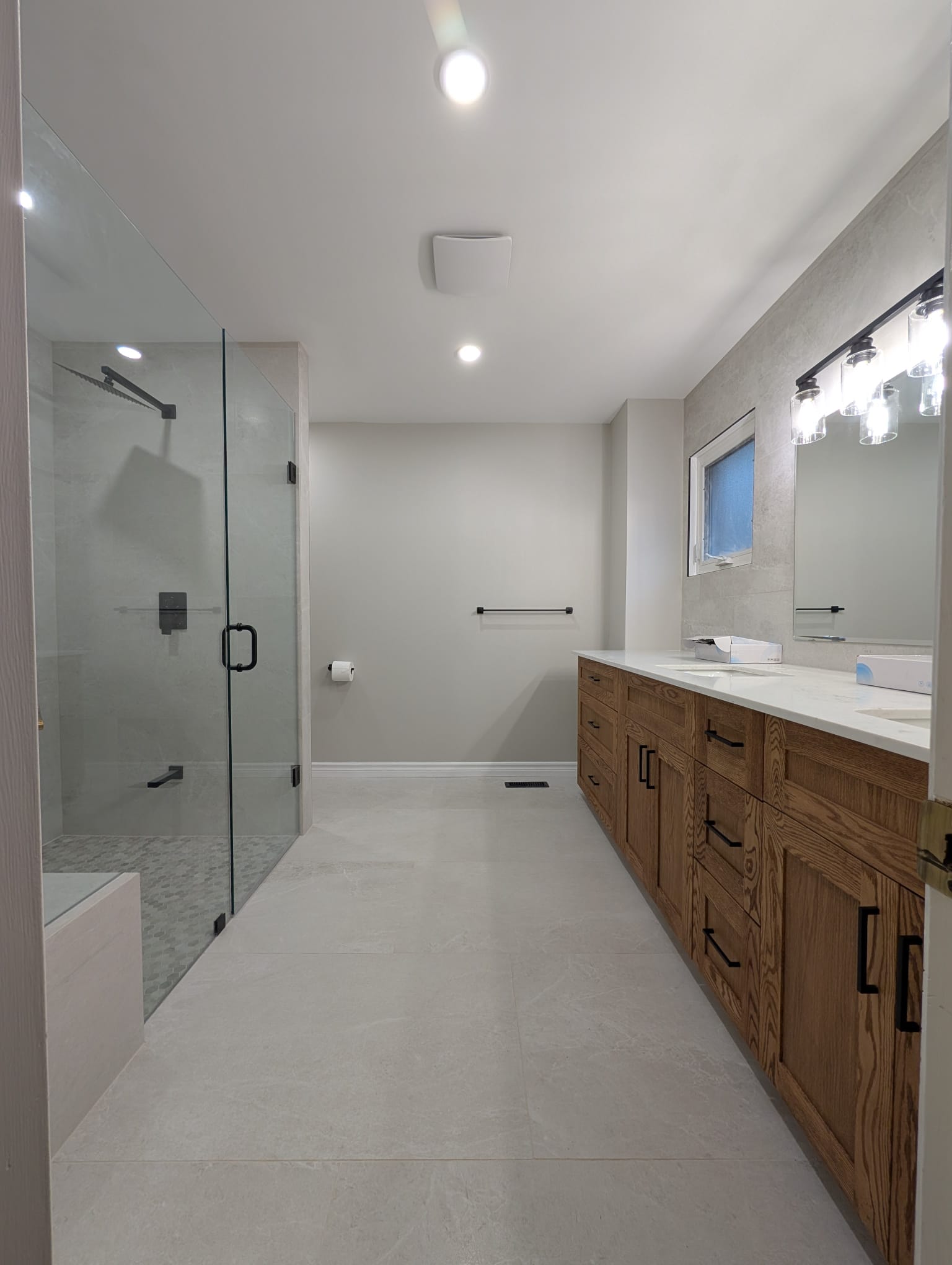 Modern bathroom with glass shower and wooden vanity
