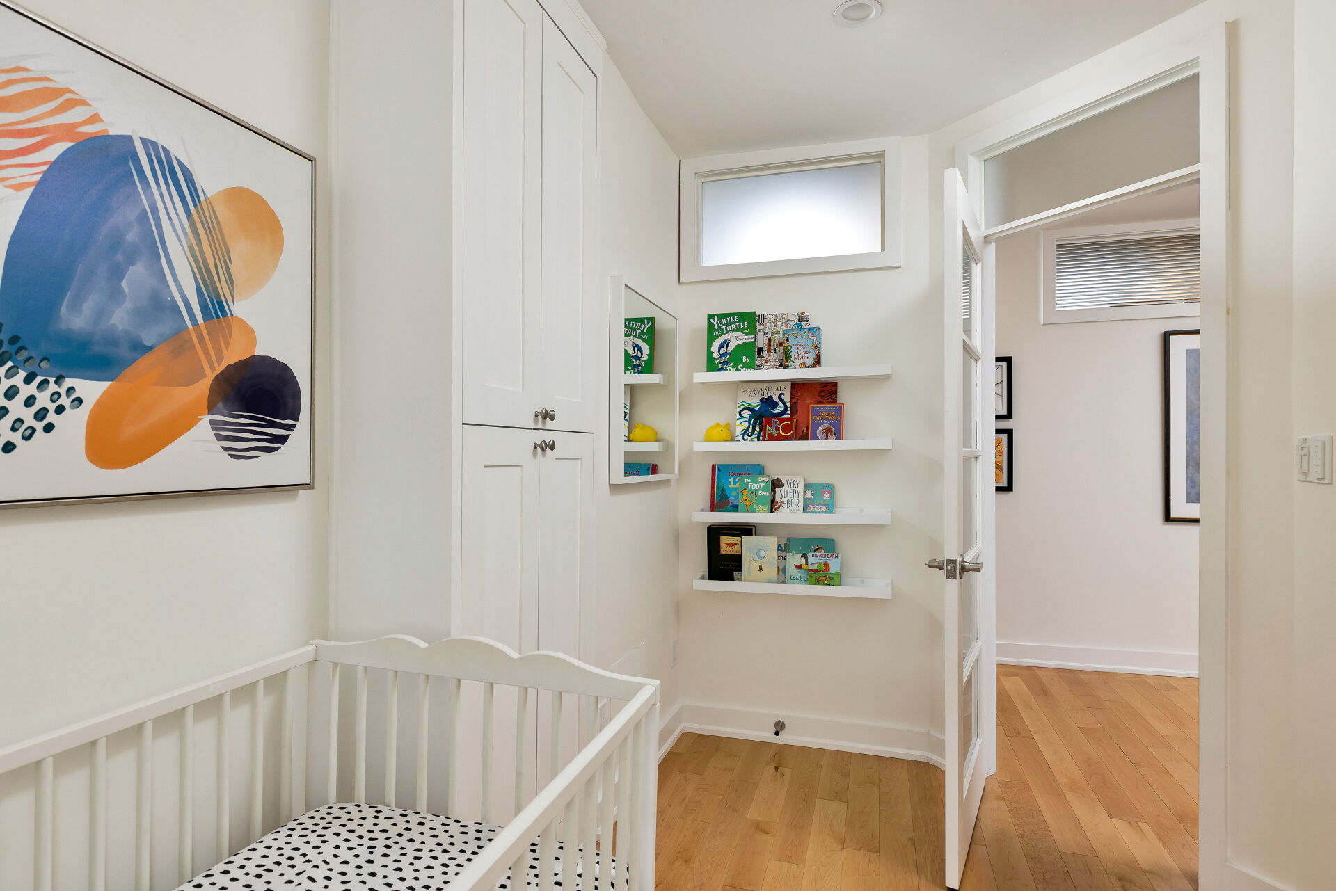 Bright nursery with crib and wall bookshelves
