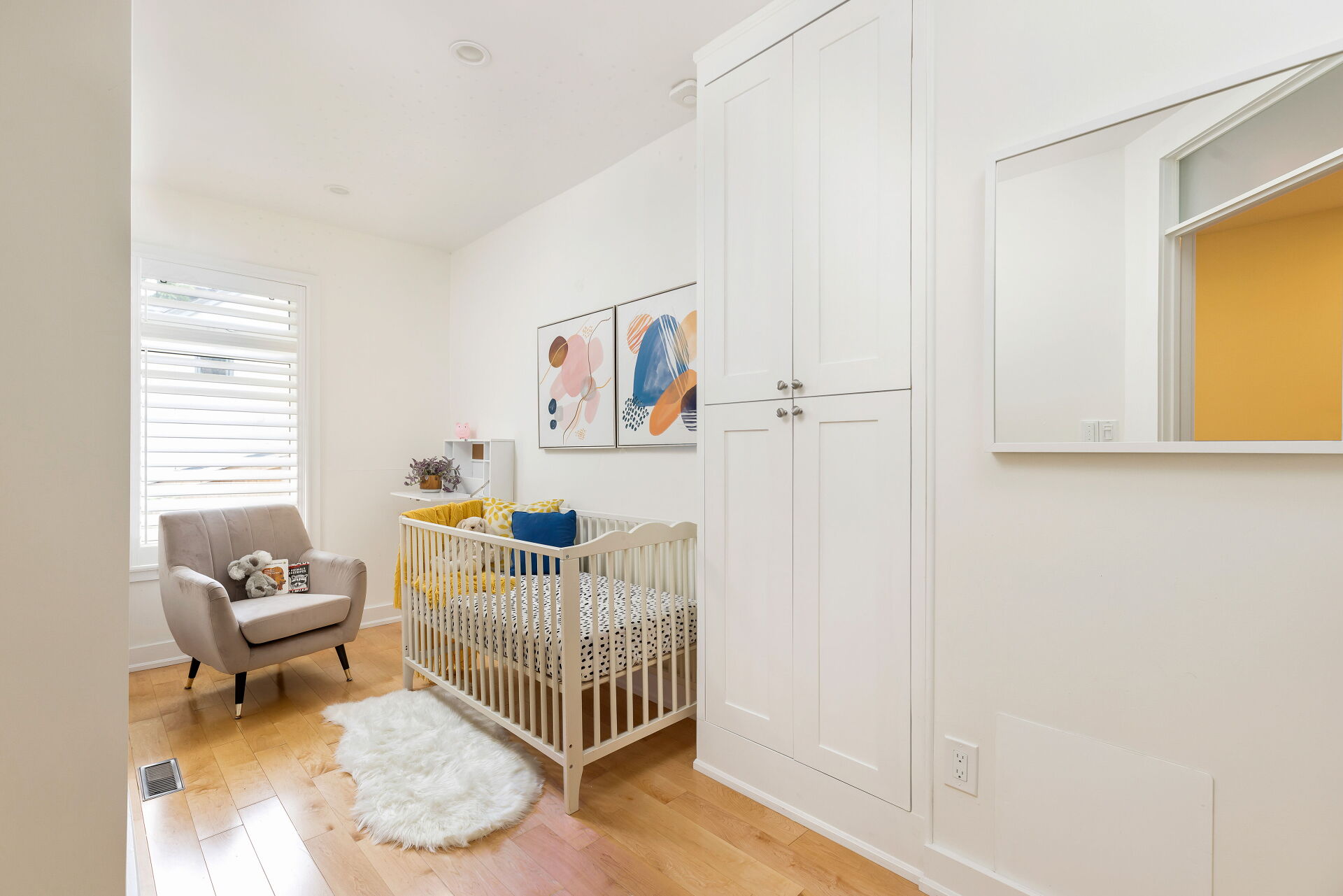 Bright modern nursery with crib and armchair