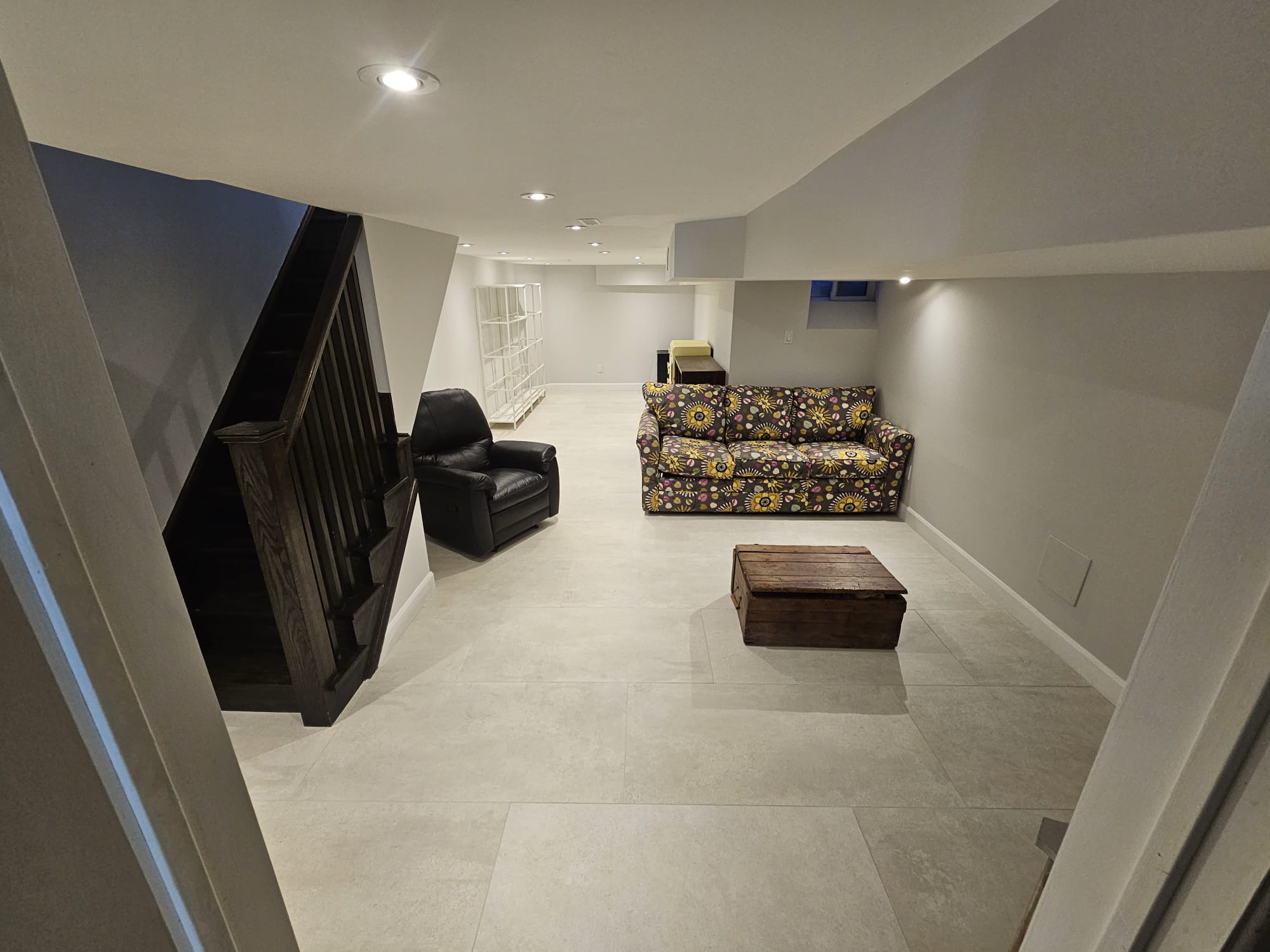 Finished basement living room with staircase and couch