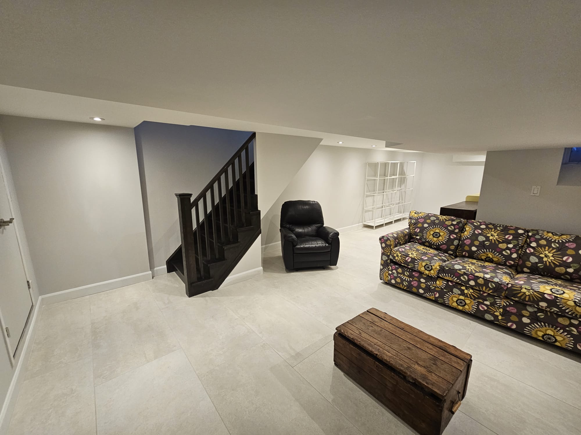 Finished basement living area with staircase and sofa